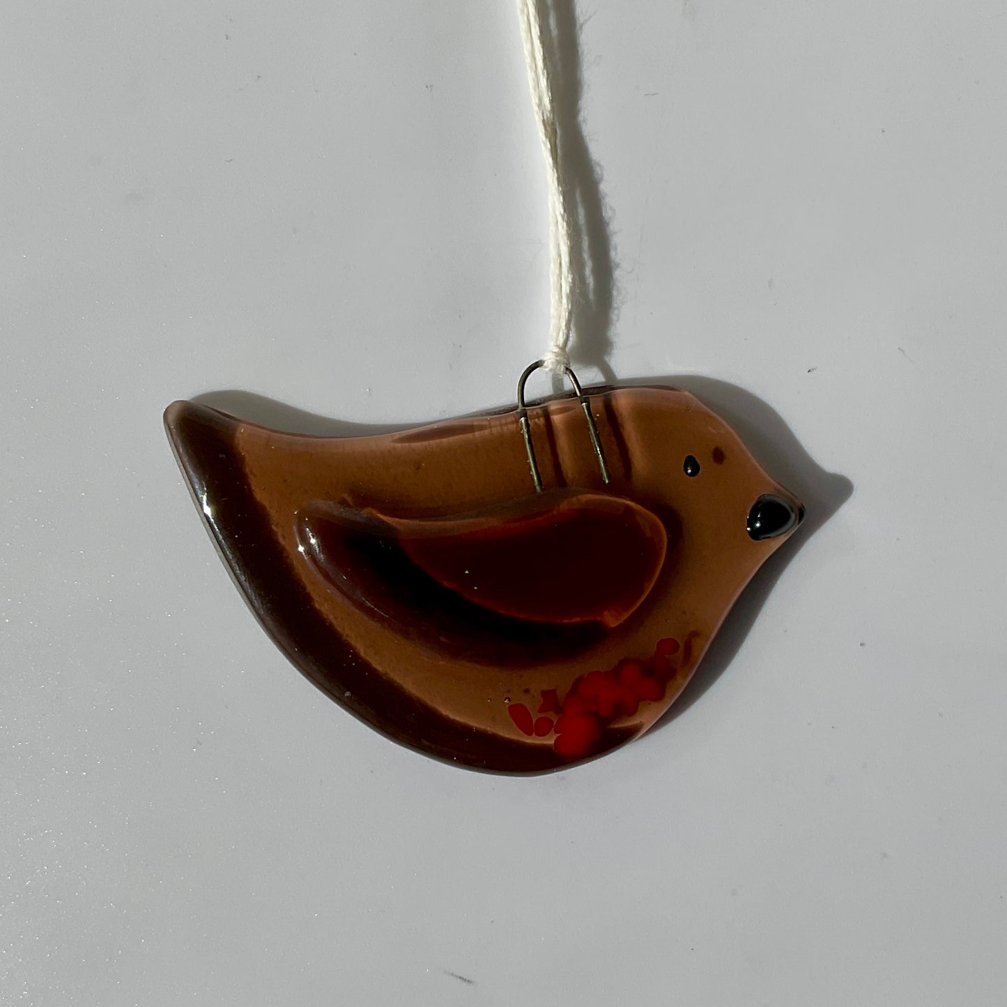 A bronze fused glass bird ornament.