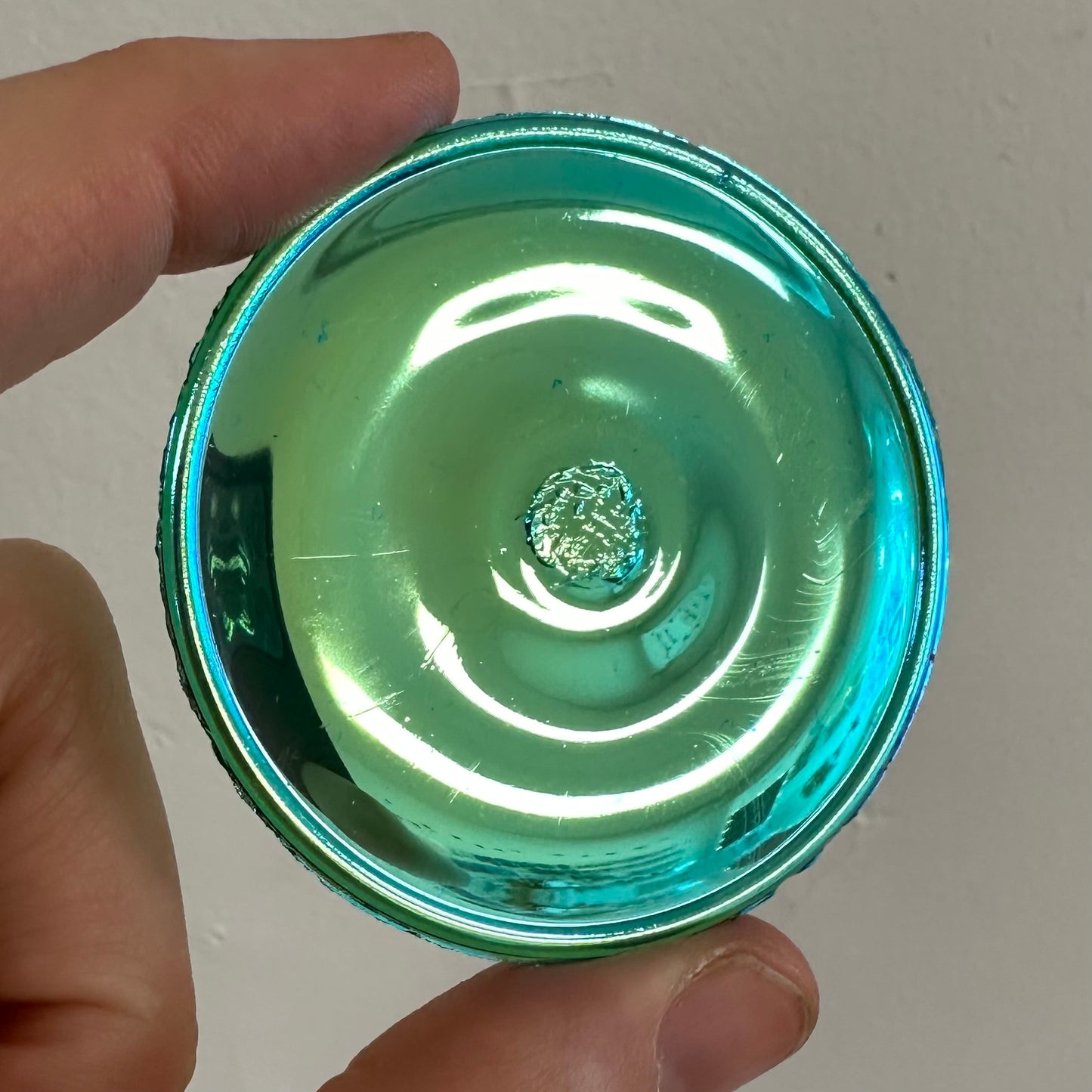 An iridescent emerald green glass rondel for stained glass.