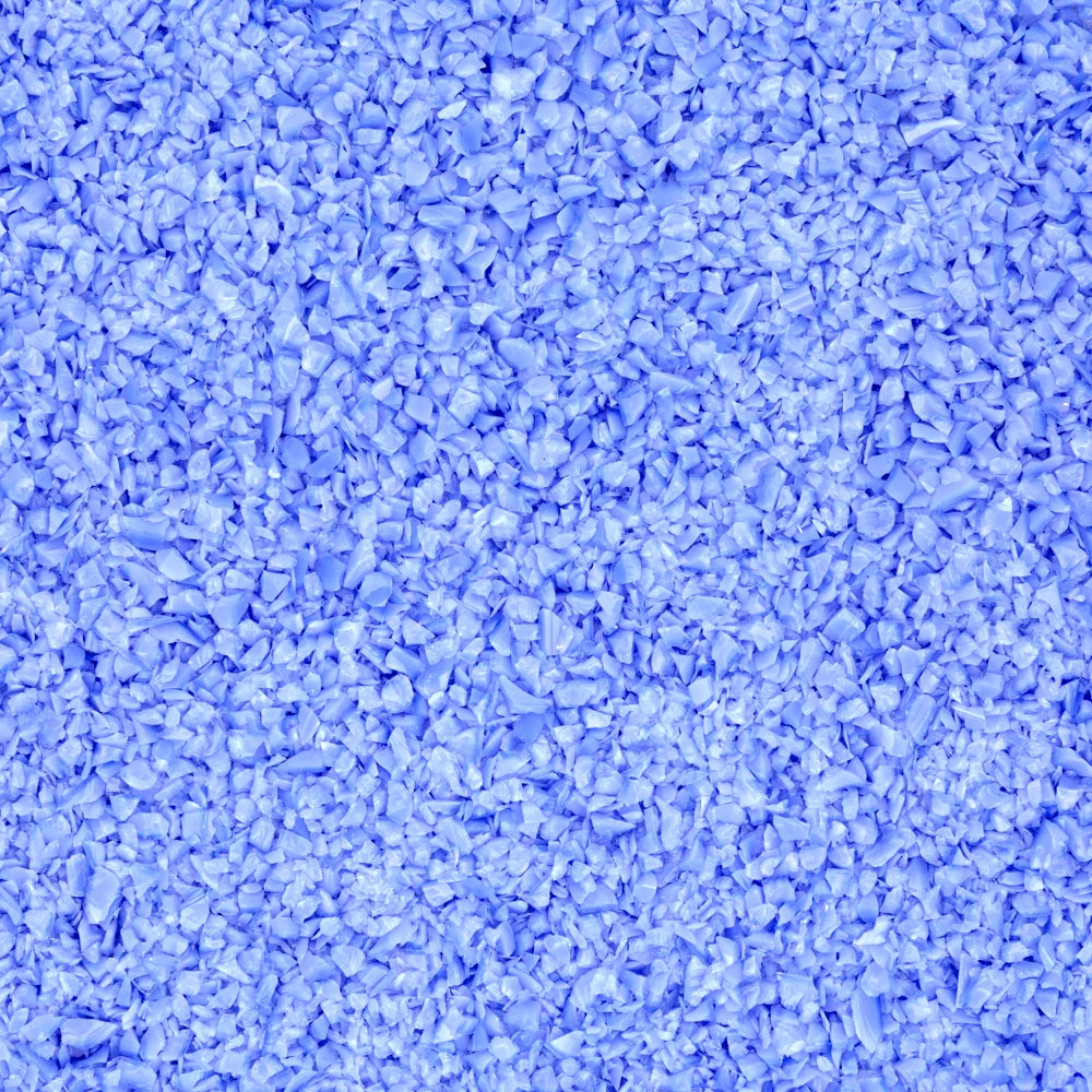 A close-up texture shot of light blue plastic pellets or shredded flakes filling the entire frame.