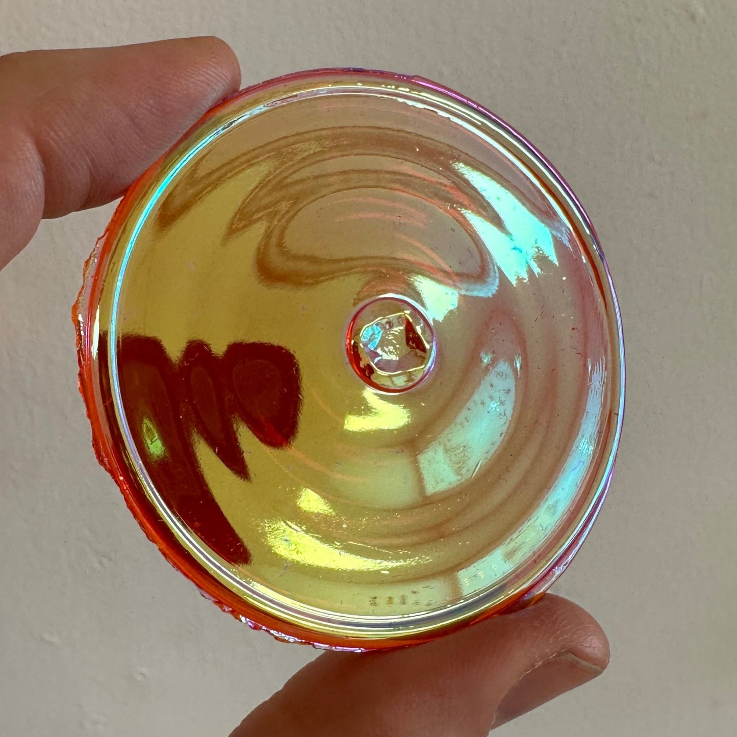 An iridescent orange glass rondel.