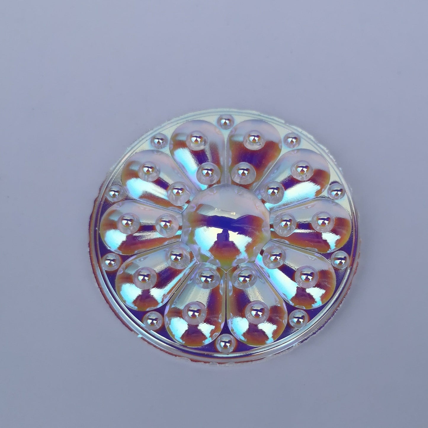 A round, flat-backed 65mm iridescent jewel with a trichroic coating that reflects multiple colors.