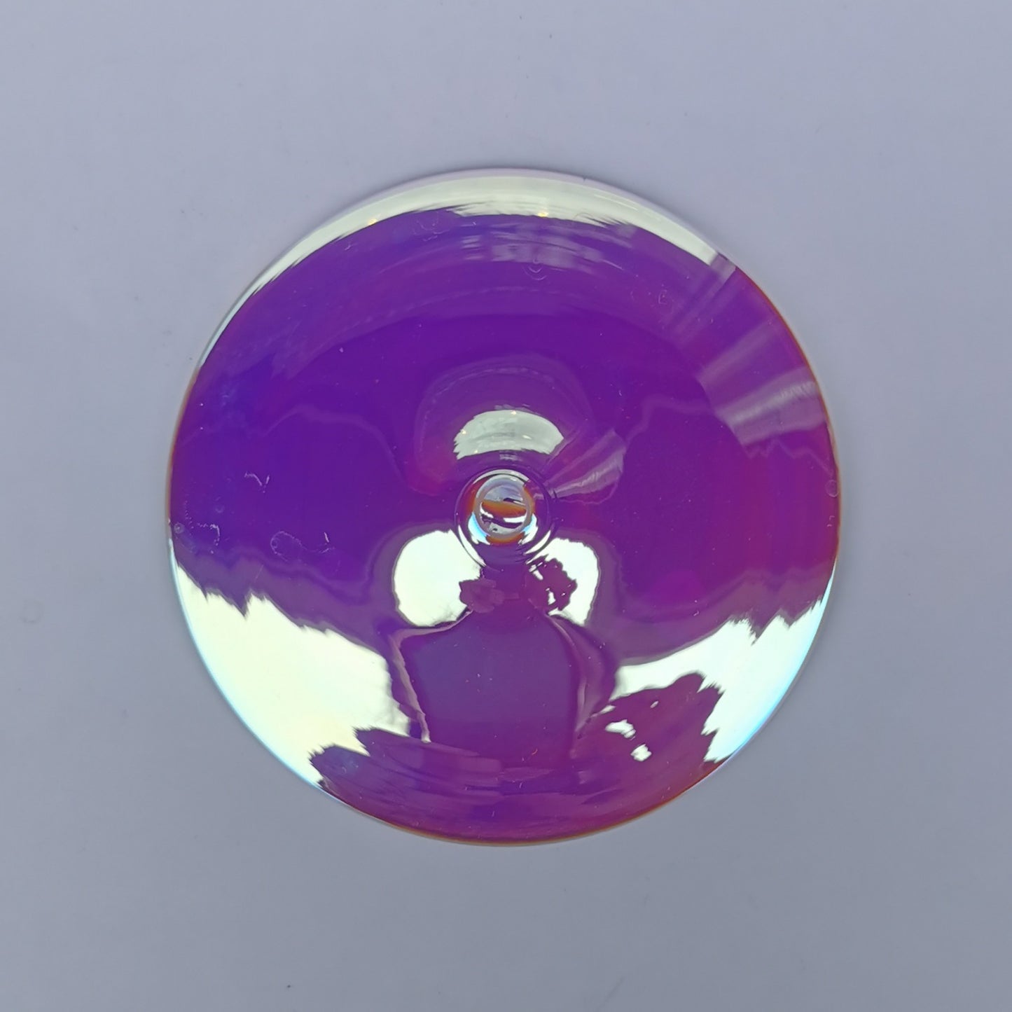 A trichroic glass rondel for stained glass work, frontlit.