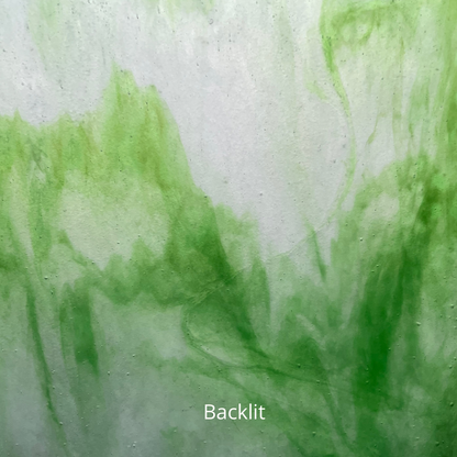 A backlit photo of a piece of white and green sheet glass for stained glass.