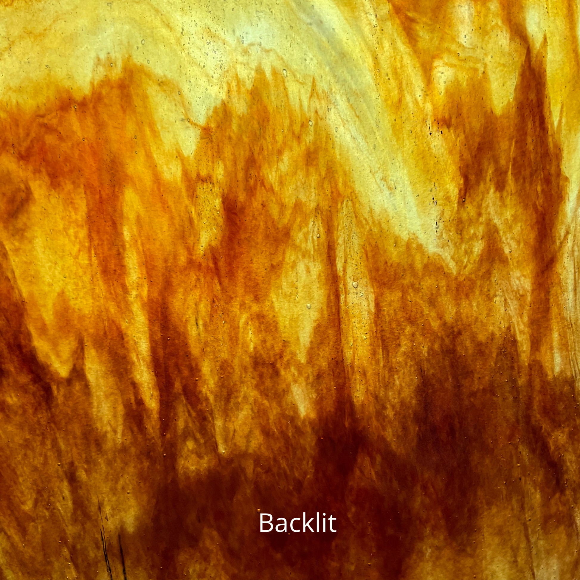 A backlit photo of a sheet of brown and amber glass for stained glass.