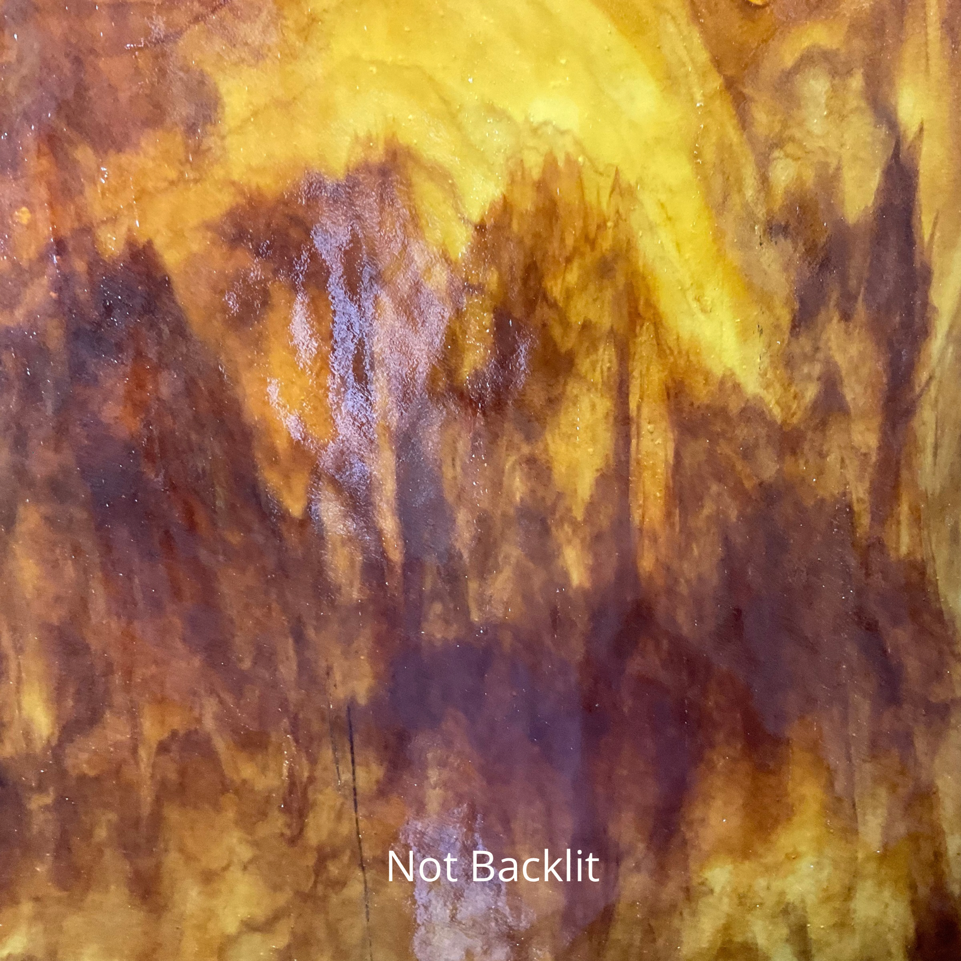 A front-lit photo of a sheet of brown and amber glass for stained glass.