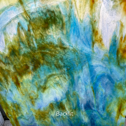 A backlit photo of a blue and yellow sheet of glass for stained glass.