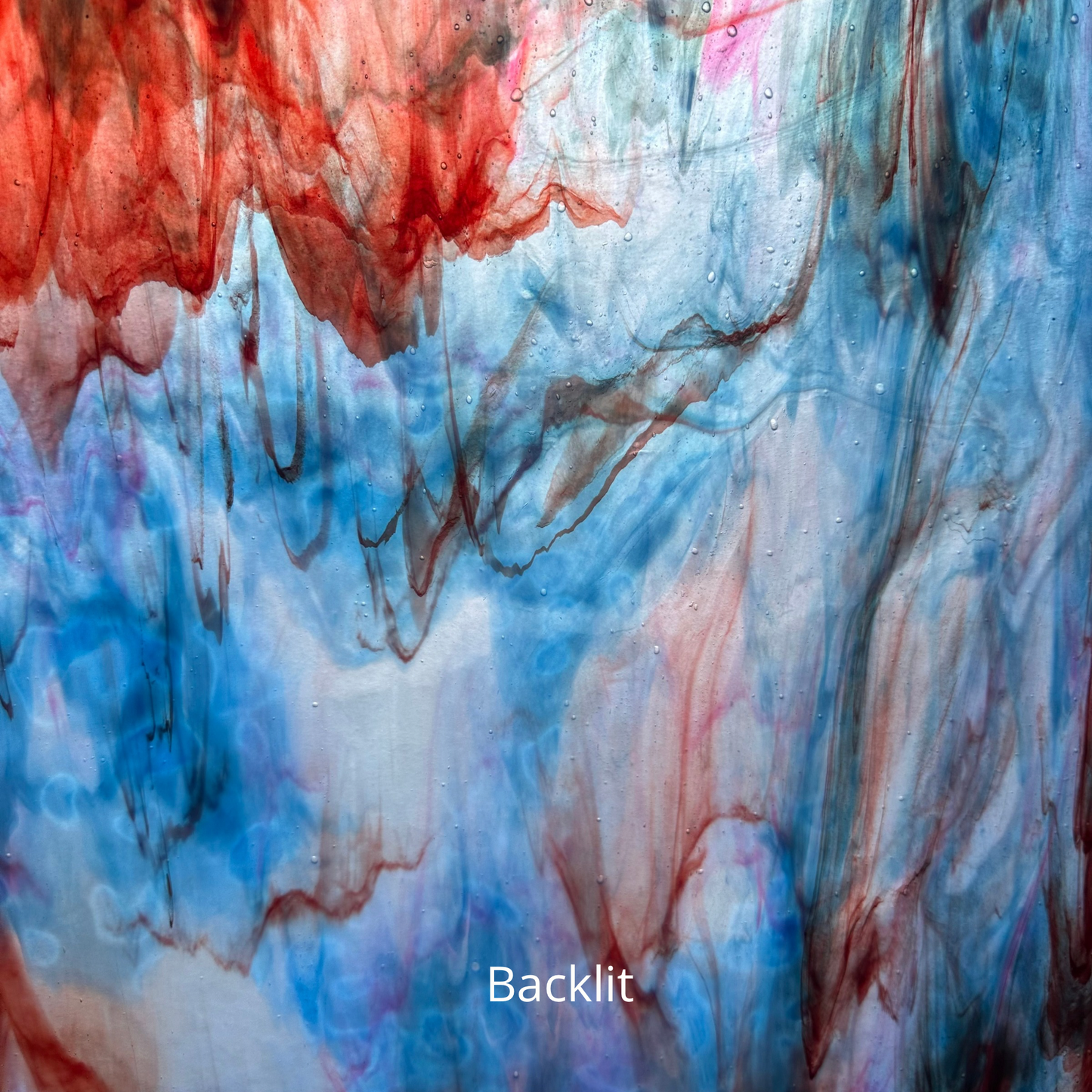 A backlit photo of blue and red streaky glass.