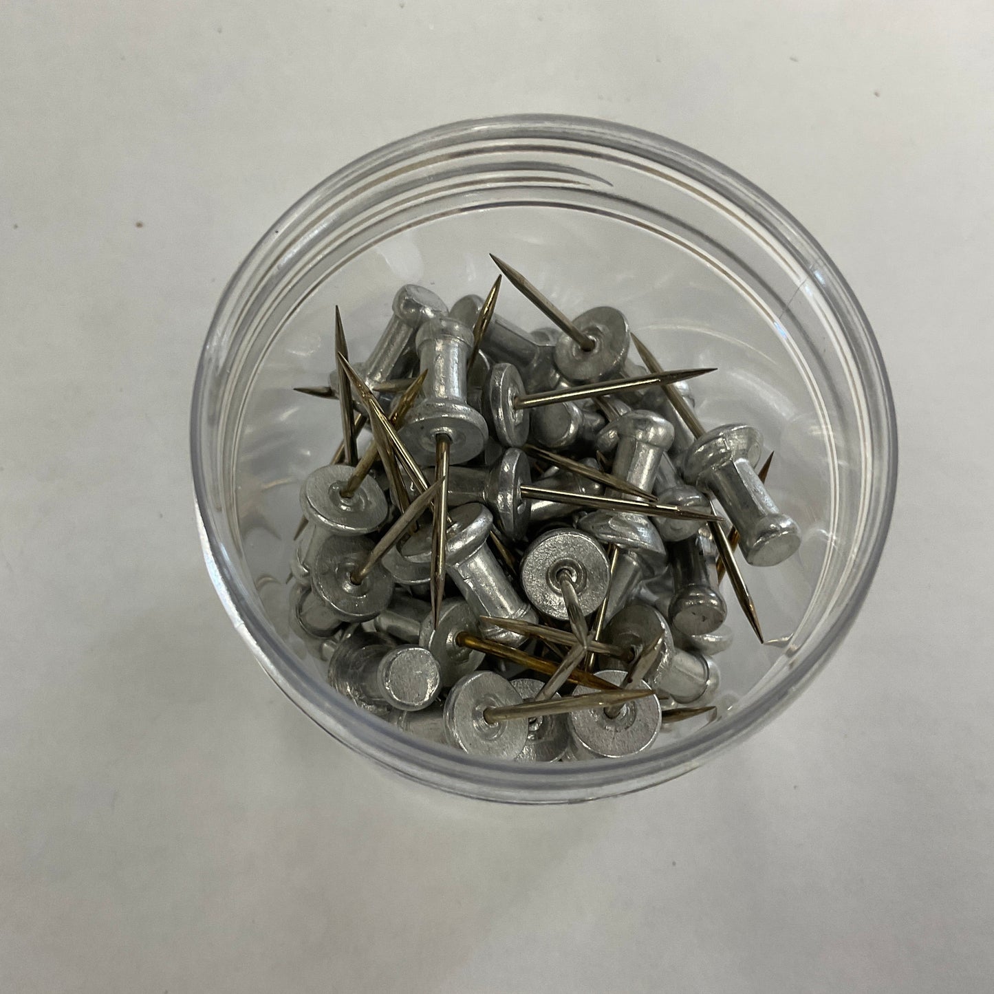 A jar of aluminium push pins for stained glass projects.