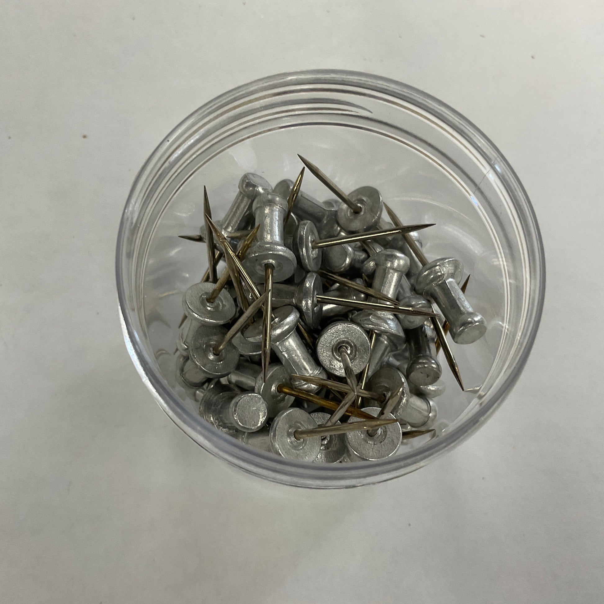 A jar of aluminium push pins for stained glass projects.