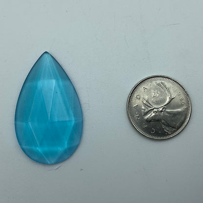 A blue faceted teardrop glass jewel.