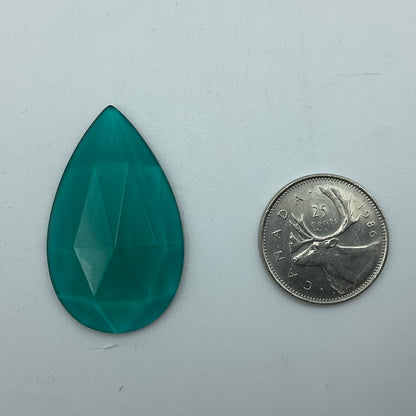 A blue-green faceted teardrop glass jewel.
