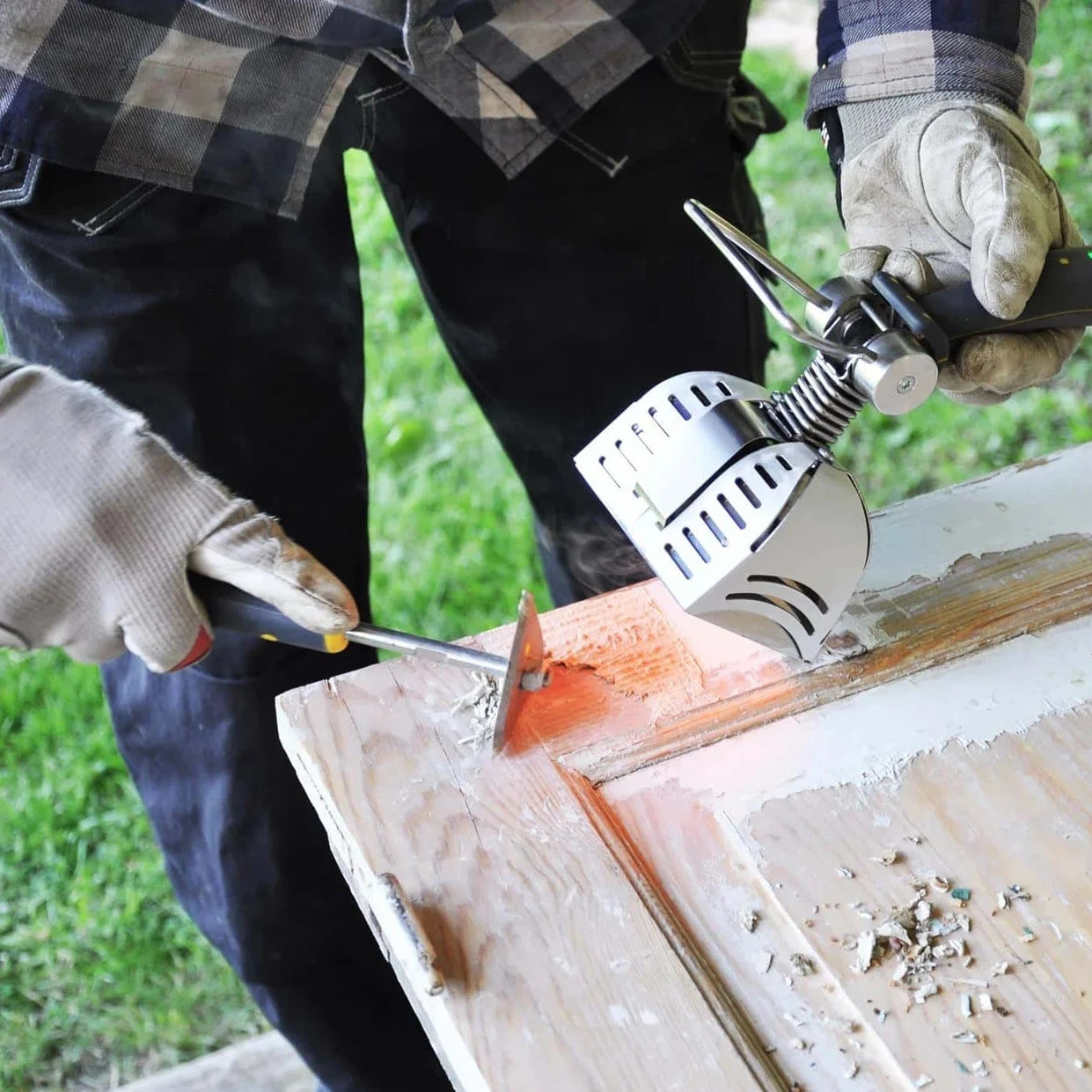 Person sanding a wooden surface outdoors with a sander.
