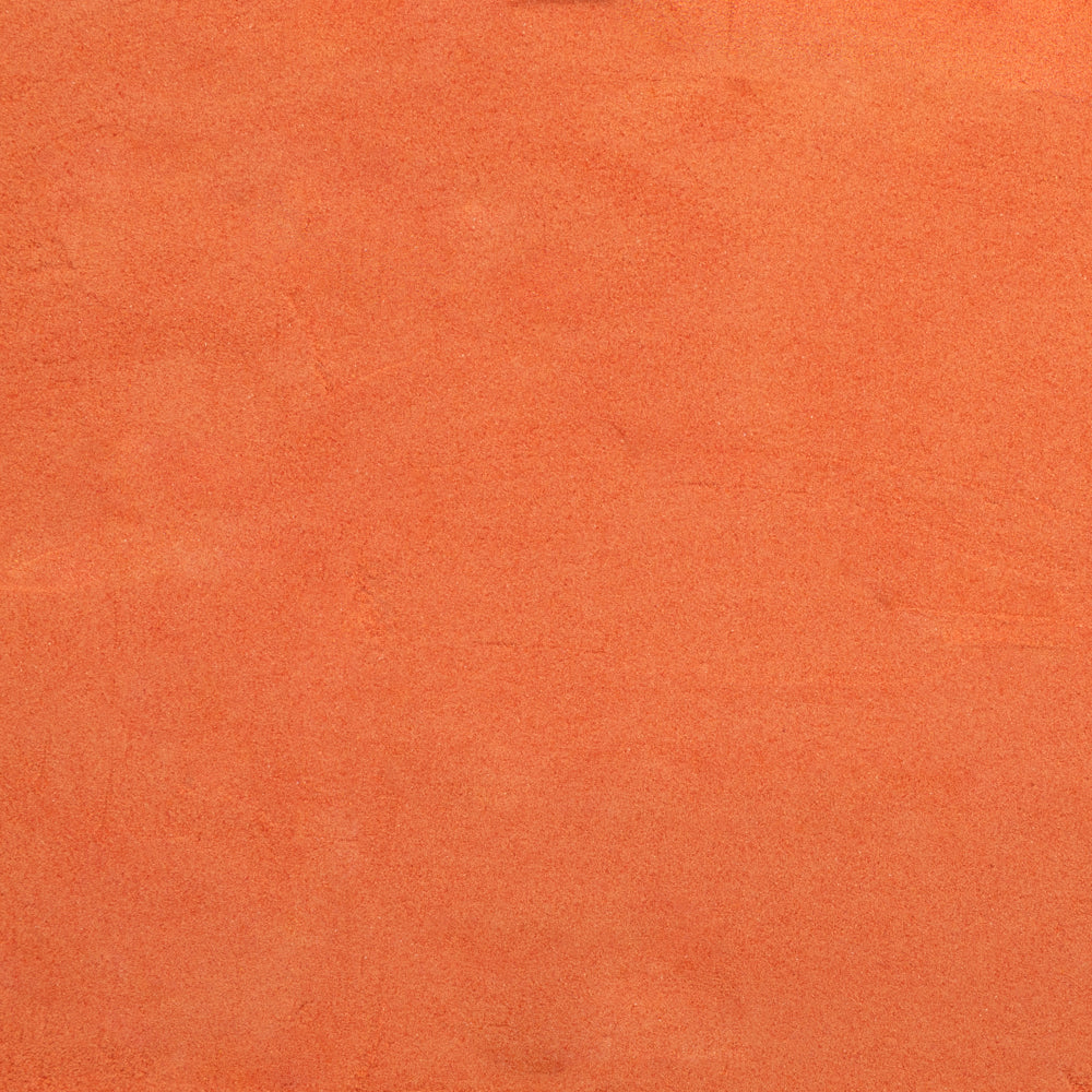Close-up of an orange-colored System 96 frit, typically used for glass crafting.