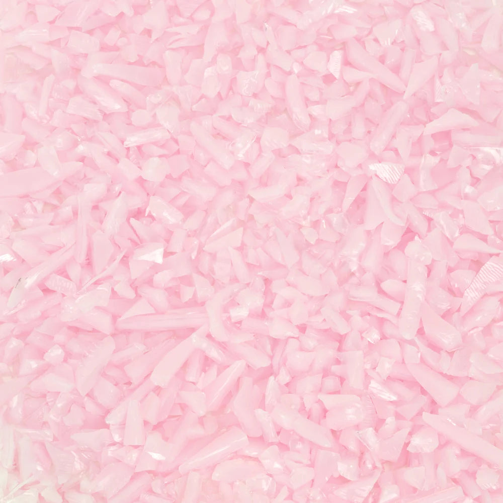 Close-up of pink opal frit, showing the texture and color of the glass pieces.