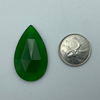A green faceted teardrop glass jewel.