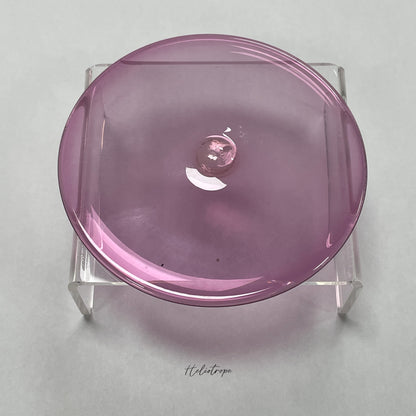 A purple-pink hand blown glass rondel for stained glass work.