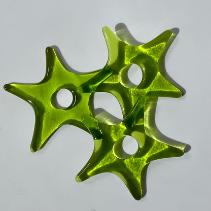 Three lime-coloured fused glass star ornaments.