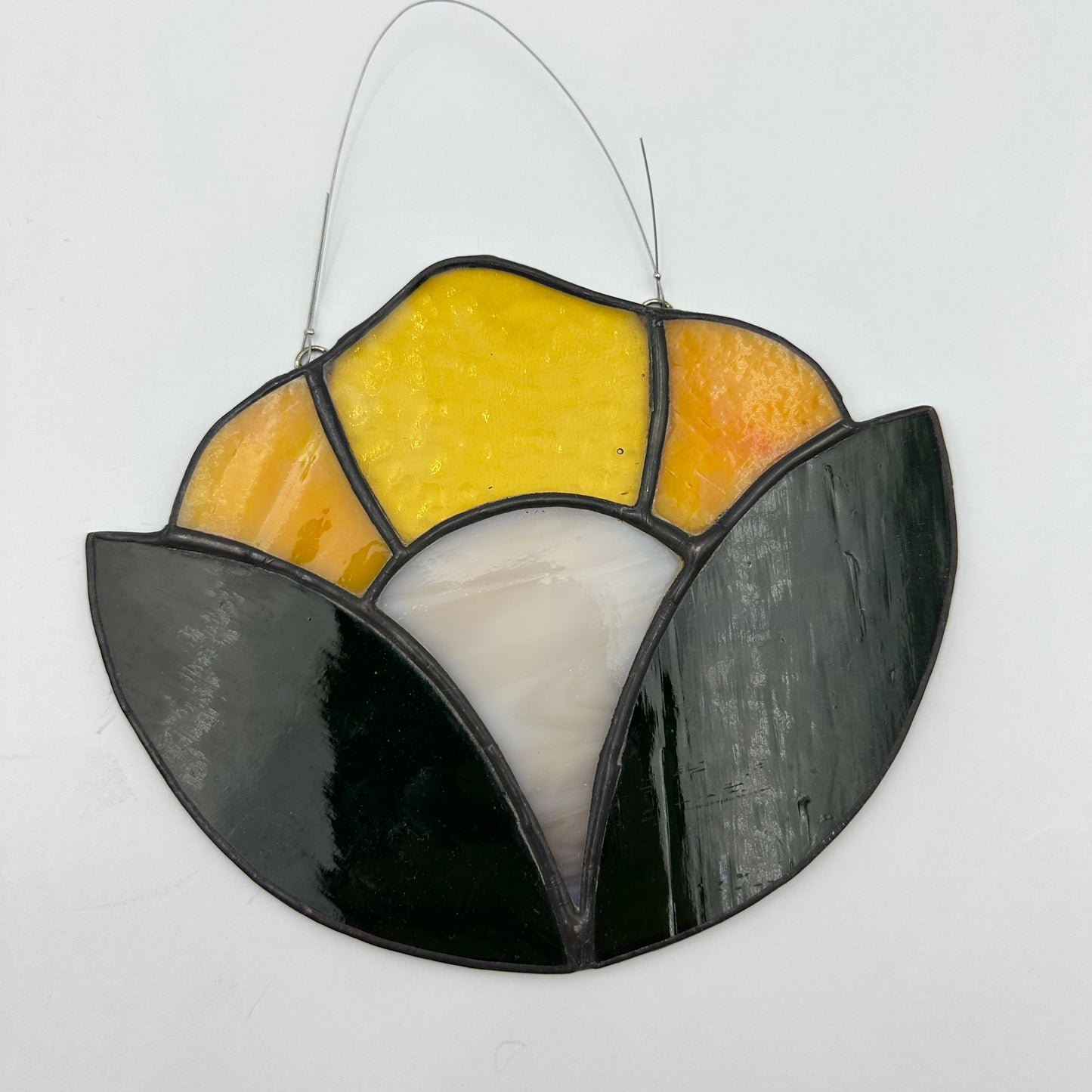 Stained glass panel with yellow, orange, and white sections on a white background