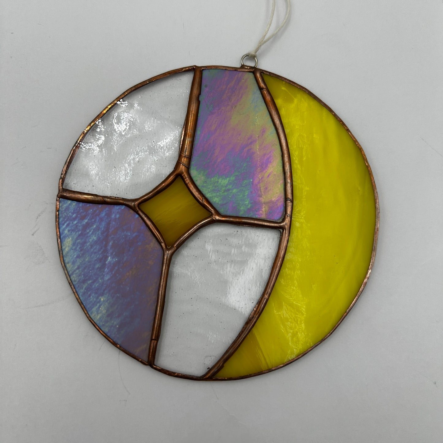 Stained glass circular panel with colorful segments on a white background