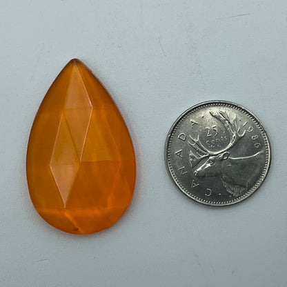 An orange faceted teardrop glass jewel.