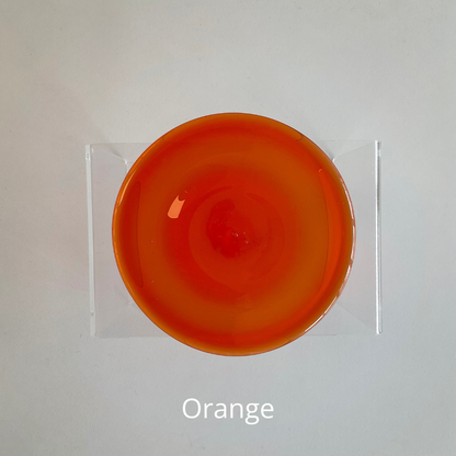 An orange hand blown glass rondel for stained glass work.