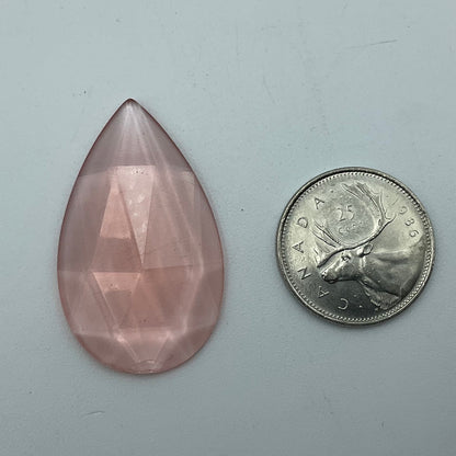 A pink faceted teardrop glass jewel.