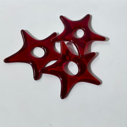 Three red fused glass star ornaments.
