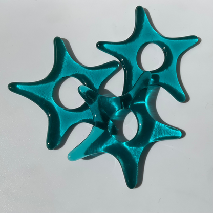 Three teal fused glass star ornaments.