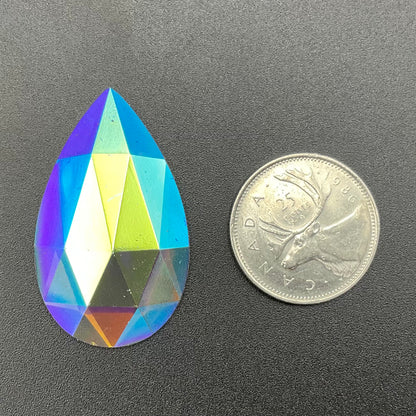 A trichroic coated clear faceted teardrop-shaped jewel.