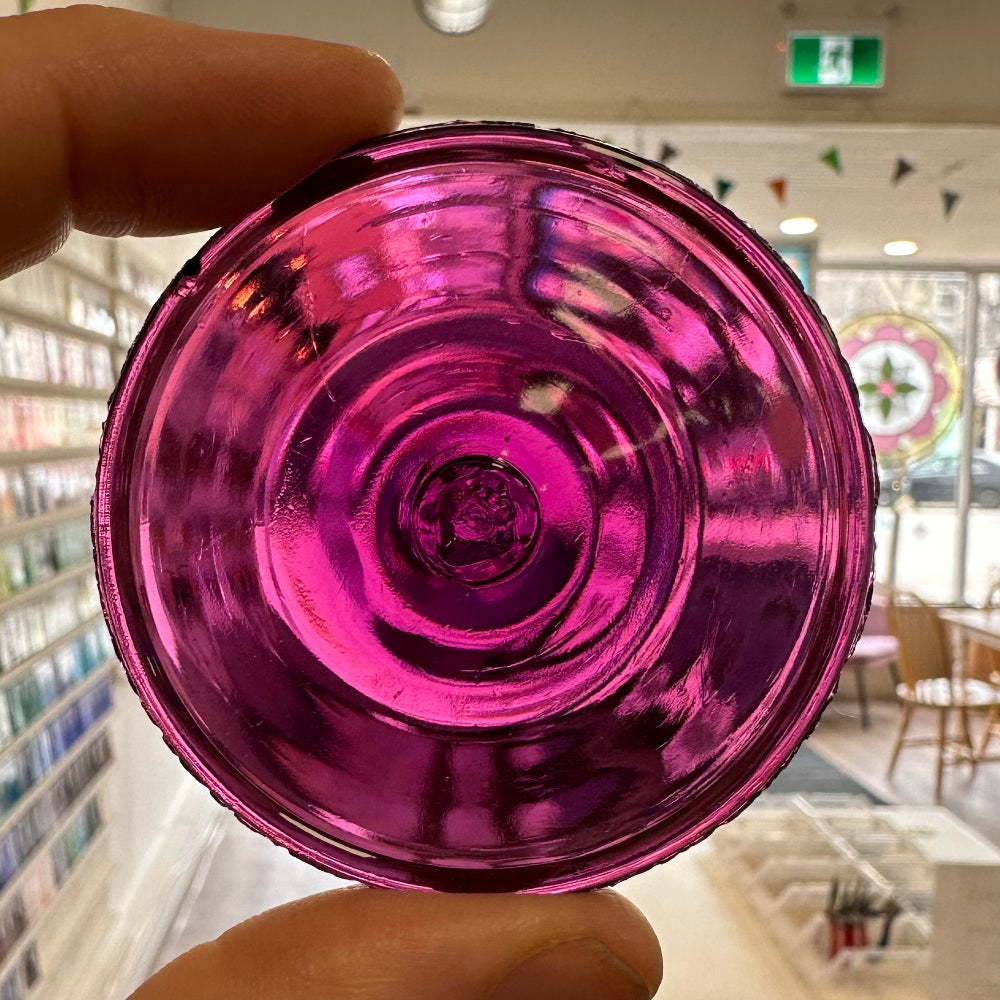 A violet glass rondel for stained glass.