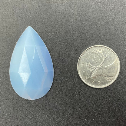 A white faceted teardrop glass jewel.