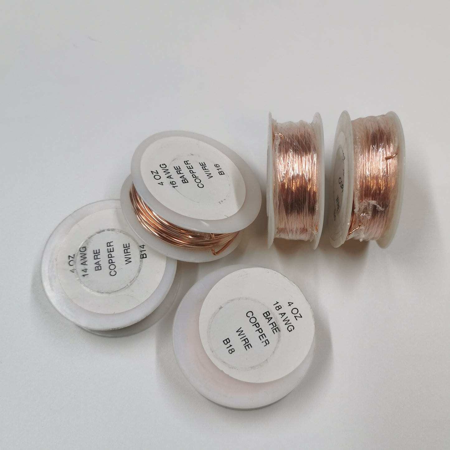 Five rolls of bare copper wire in a pile