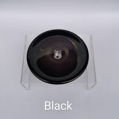 A black hand blown glass rondel for stained glass work.