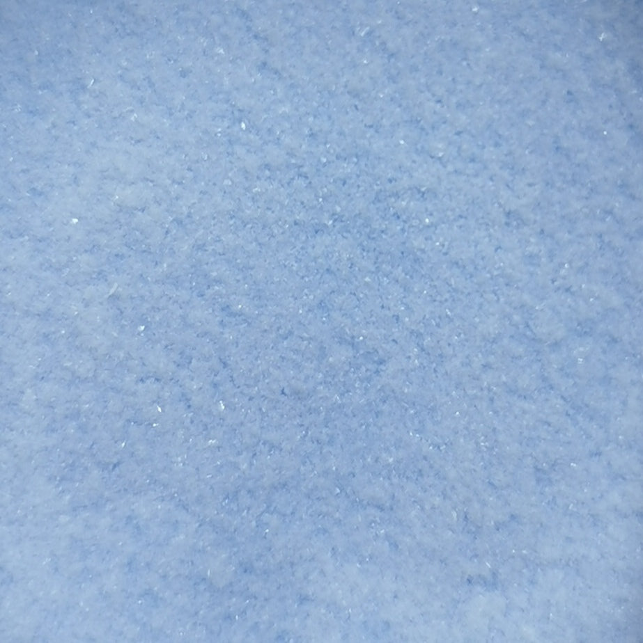 Close-up of light blue transparent frit, showing granular texture.