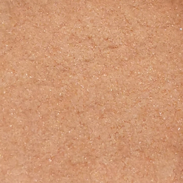 Close-up view of a cherry red colored frit powder, typically used in glassmaking.