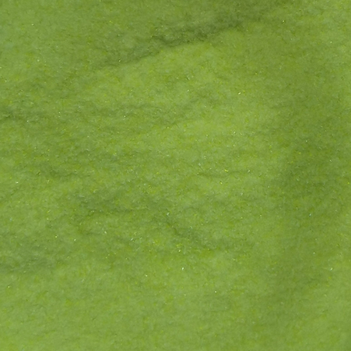 Close-up view of a bottle of OGT Lemongrass Opal 2262 System 96 8oz Frit, showing the textured surface of the frit.