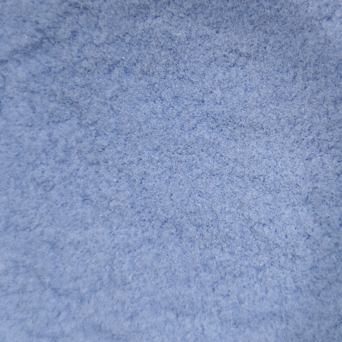 Close-up view of a blue opalescent frit, likely used for crafting or glasswork.