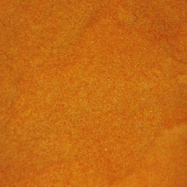 Close-up of an orange opalescent glass frit texture.