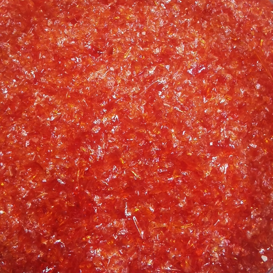 Close-up view of a cherry red colored frit crushed glass, typically used in glassmaking.