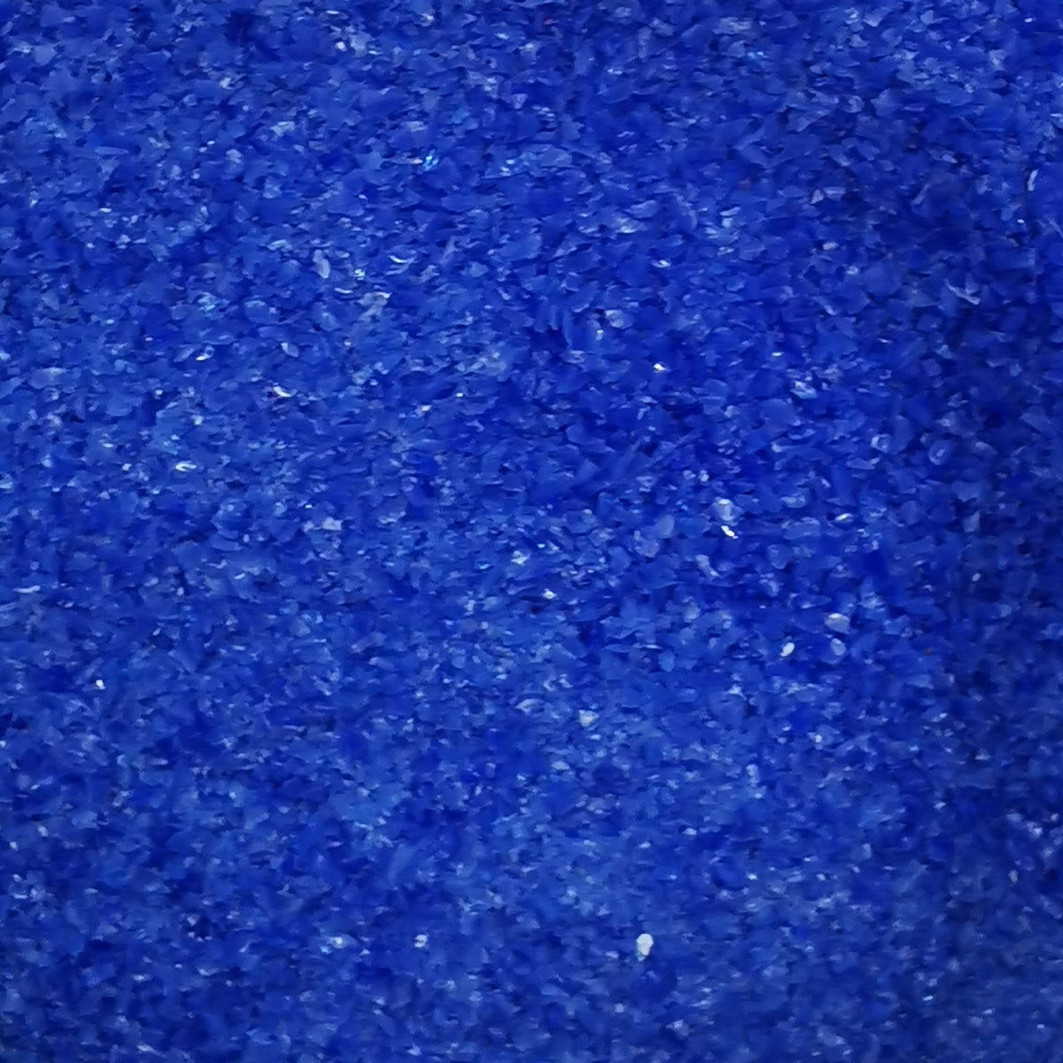 Close-up view of a blue opalescent frit, likely used for crafting or glasswork.
