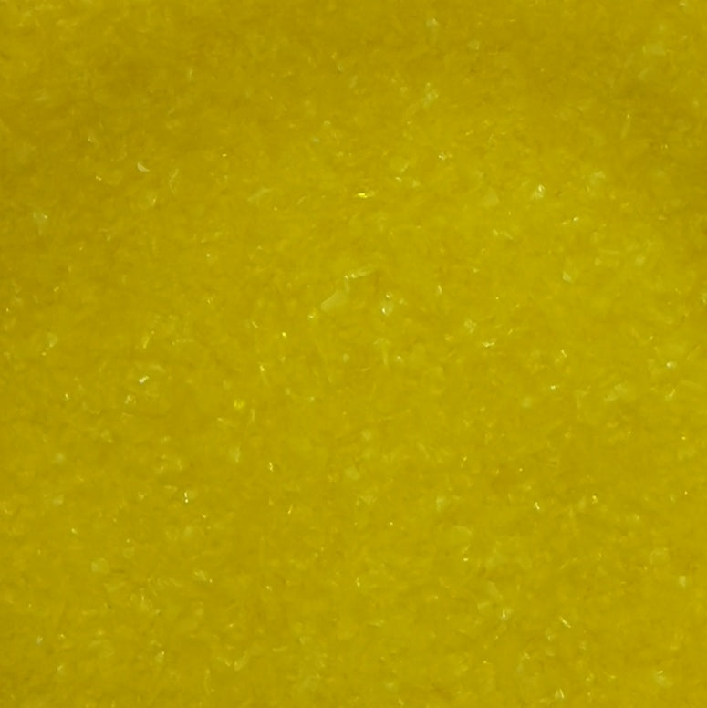 Close-up of yellow opalescent glass frit.