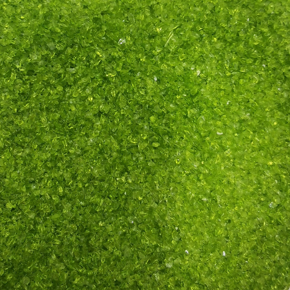 Close-up of moss green transparent frit, showing texture and color.