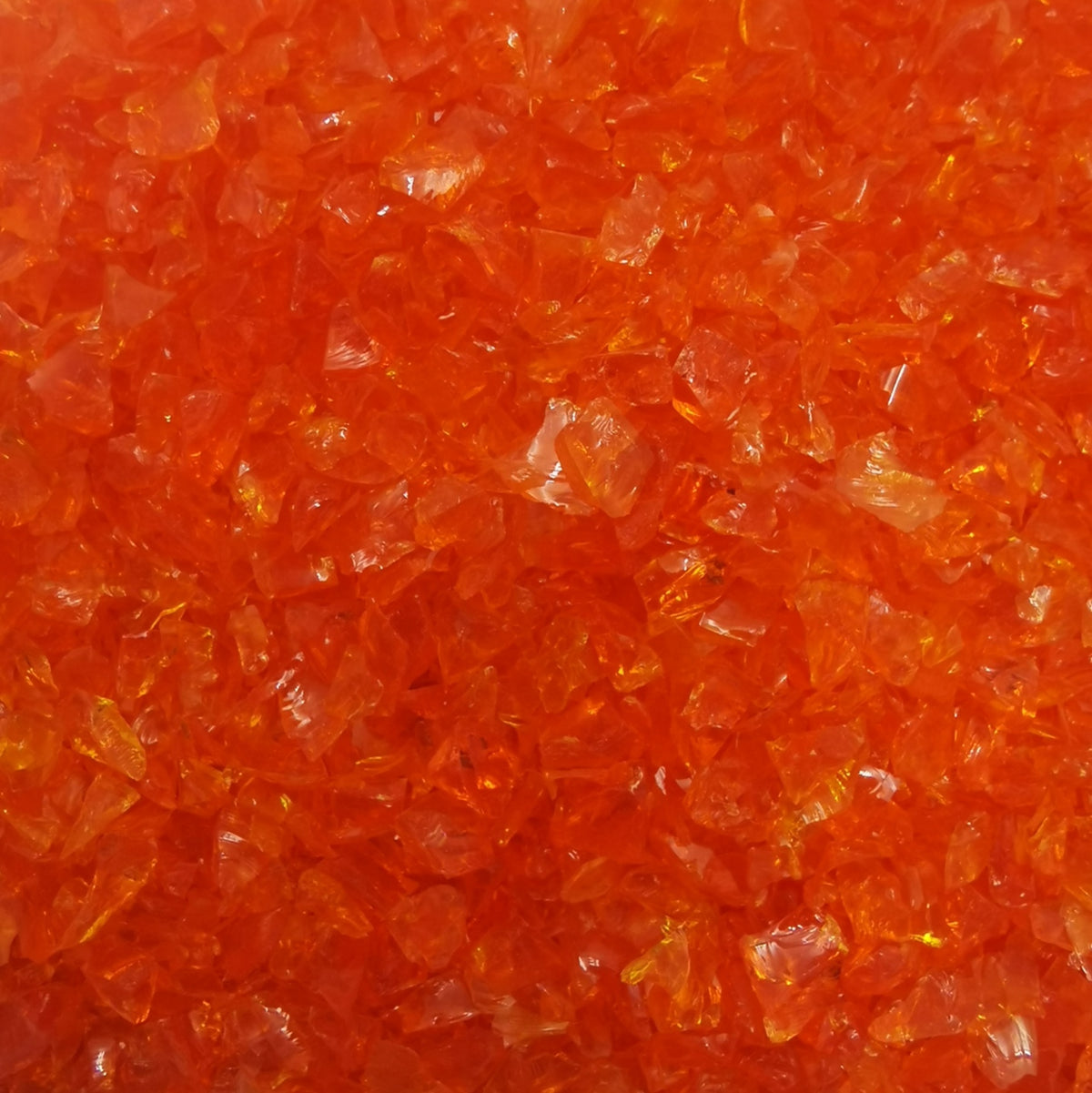 Close-up view of an orange transparent frit used in glass crafting.