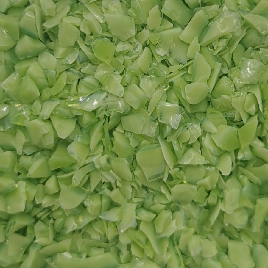 Close-up of an 8oz bottle of OGT Amazon Green Opal 2264 System 96 frit, showing the texture and green color of the material.
