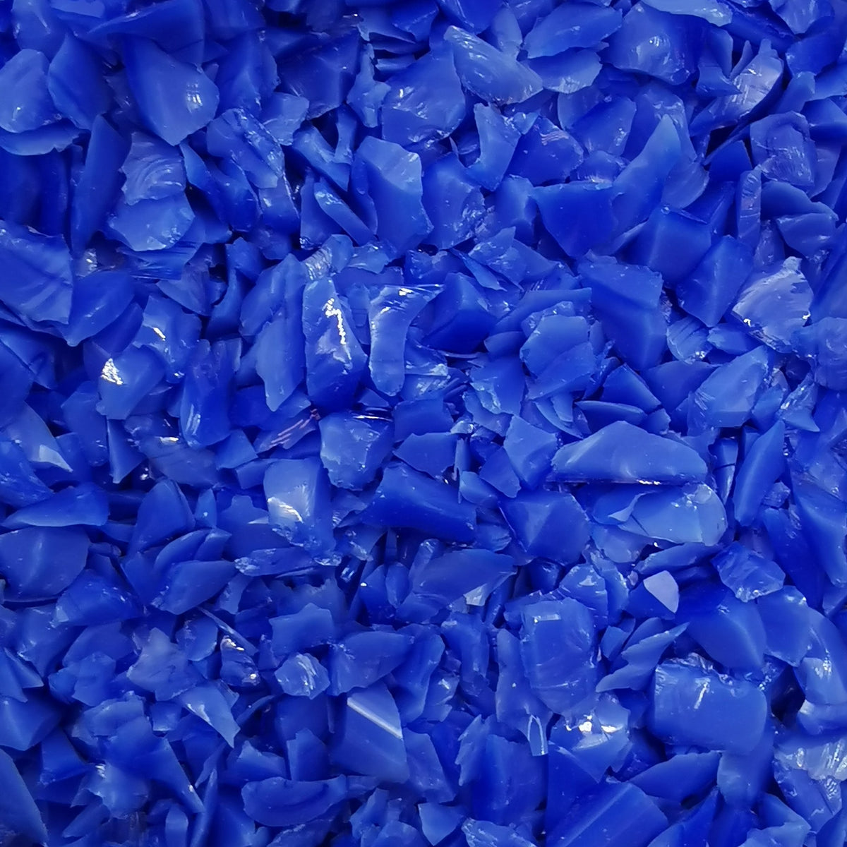 Close-up view of a blue opalescent frit, likely used for crafting or glasswork.