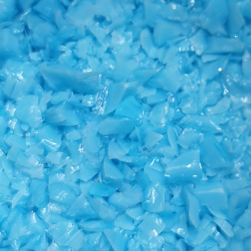 A close-up image of blue opalescent glass frit, used in glass crafting.