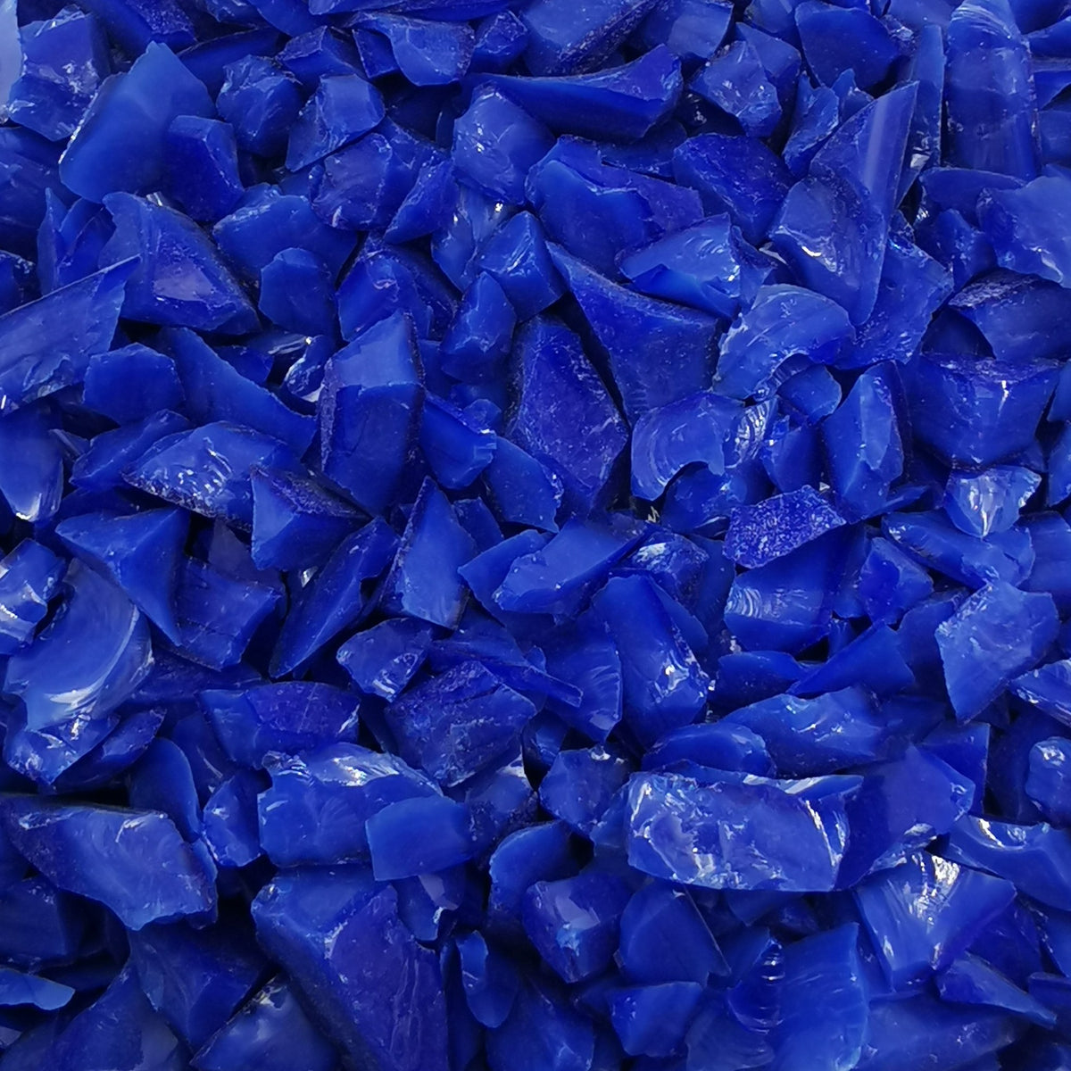 Close-up view of a blue opalescent frit, likely used for crafting or glasswork.