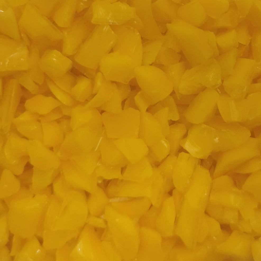 Close-up of yellow opalescent glass frit pieces.