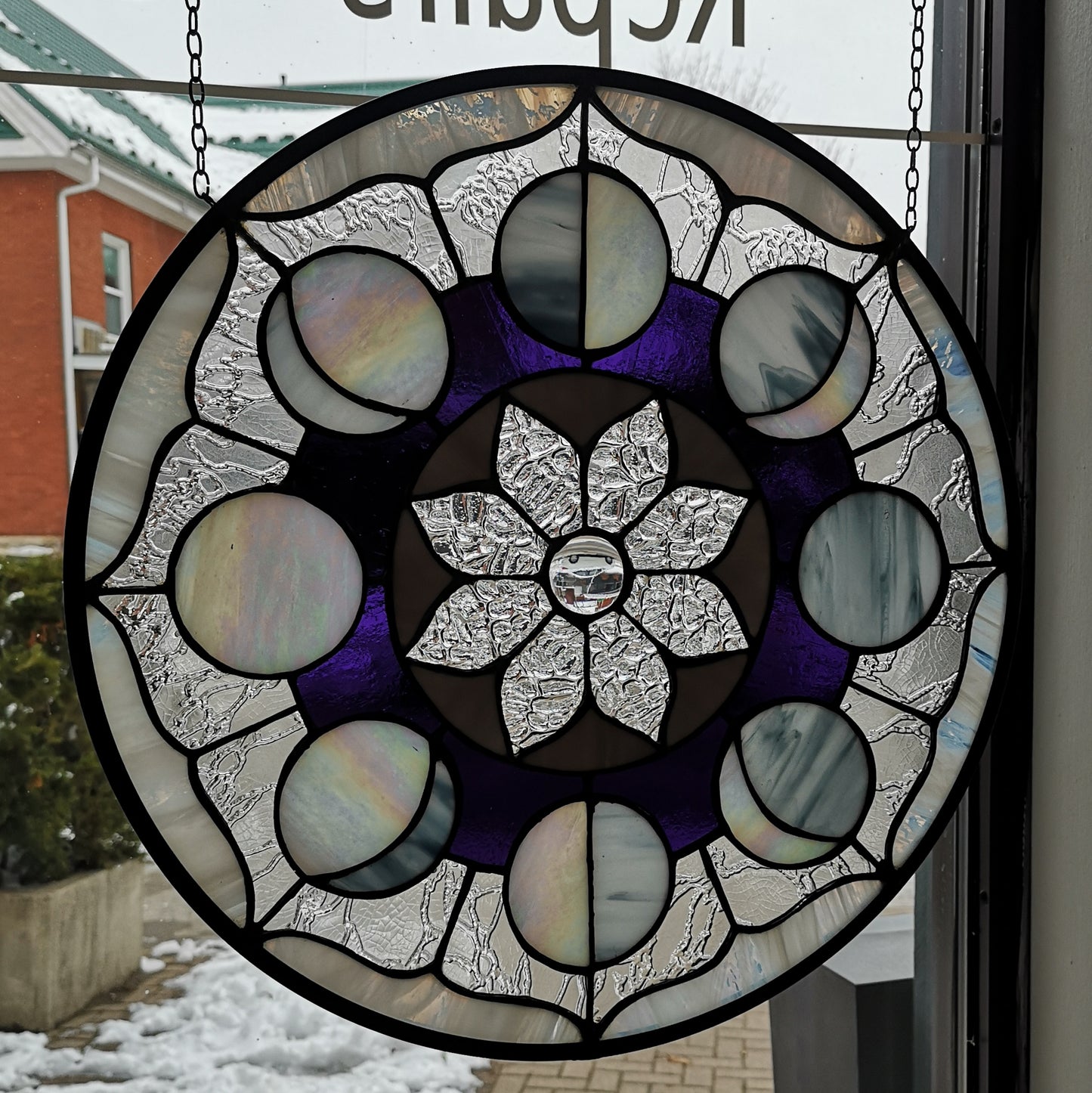 A round stained glass window of the moon phases.