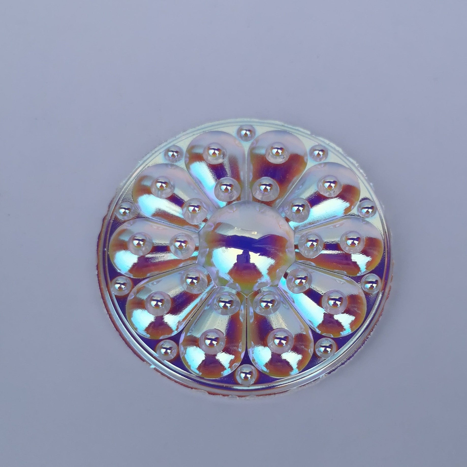 A round, flat-backed 65mm iridescent jewel with a trichroic coating that reflects multiple colors.